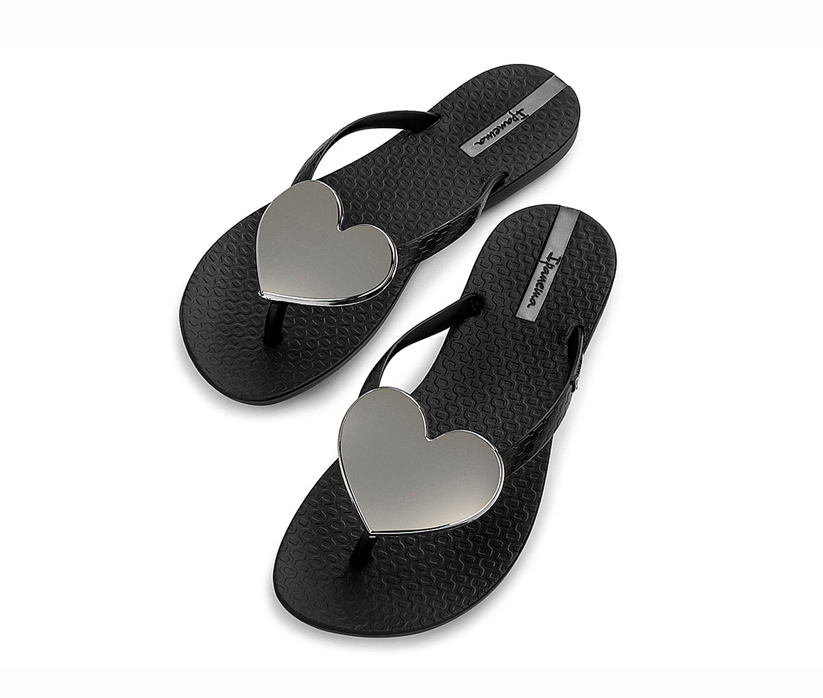 Angled view of a pair black Ipanema Wave Heart flip flops with a silver heart.